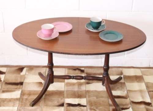 A wonderful vintage Regency style oval coffee table with brass-caped toes and rail inlay detailing