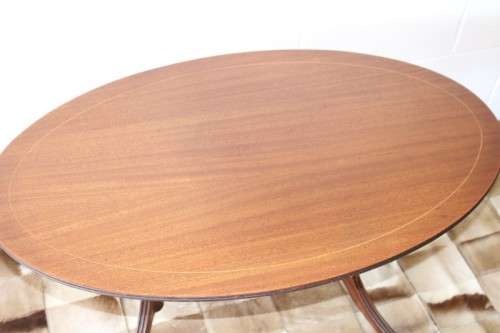 A wonderful vintage Regency style oval coffee table with brass-caped toes and rail inlay detailing