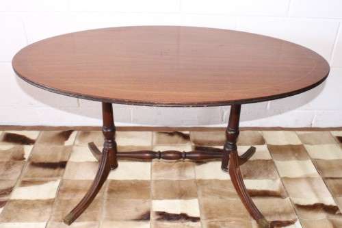 A wonderful vintage Regency style oval coffee table with brass-caped toes and rail inlay detailing