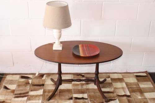 A wonderful vintage Regency style oval coffee table with brass-caped toes and rail inlay detailing