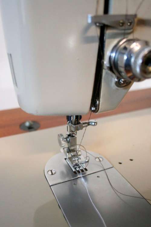 A vintage Empisal deluxe electric sewing machine in its original cabinet w/ accessories, working.