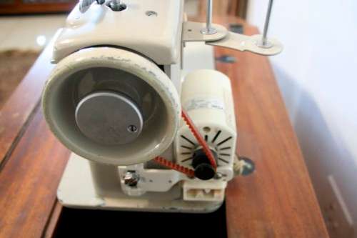 A vintage Empisal deluxe electric sewing machine in its original cabinet w/ accessories, working.