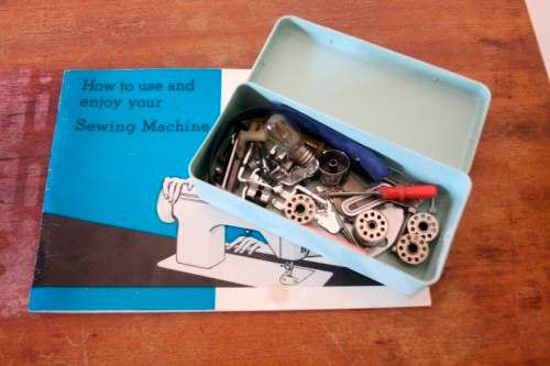 A vintage Empisal deluxe electric sewing machine in its original cabinet w/ accessories, working.