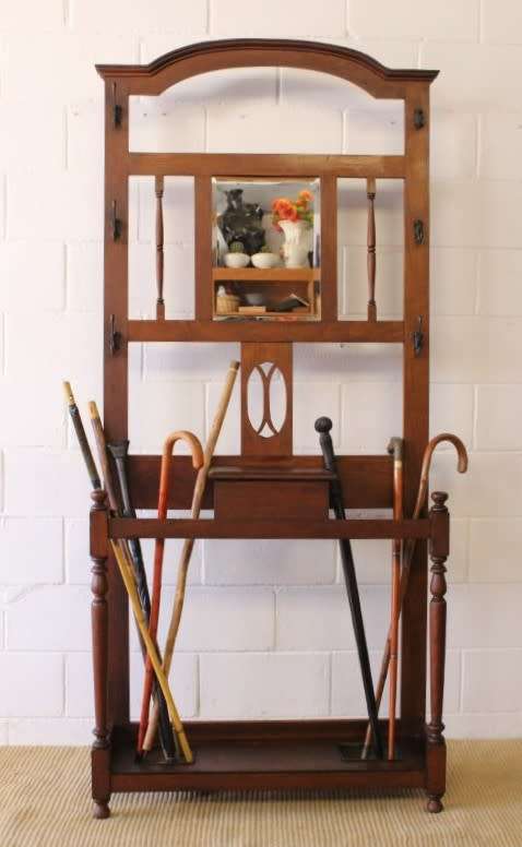 An incredible solid Oak hall stand with a bevelled mirror, "drawer" & six hooks for hats and coats!