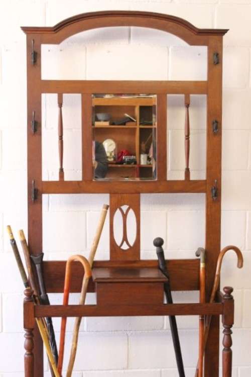 An incredible solid Oak hall stand with a bevelled mirror, "drawer" & six hooks for hats and coats!