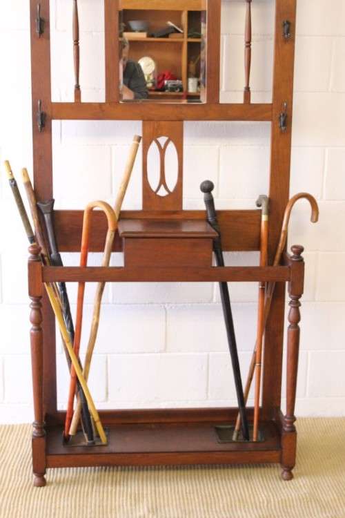 An incredible solid Oak hall stand with a bevelled mirror, "drawer" & six hooks for hats and coats!