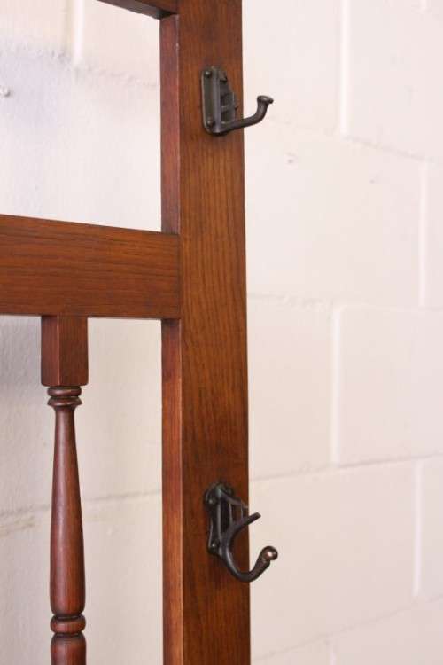 An incredible solid Oak hall stand with a bevelled mirror, "drawer" & six hooks for hats and coats!