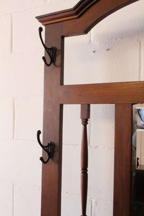 An incredible solid Oak hall stand with a bevelled mirror, "drawer" & six hooks for hats and coats!
