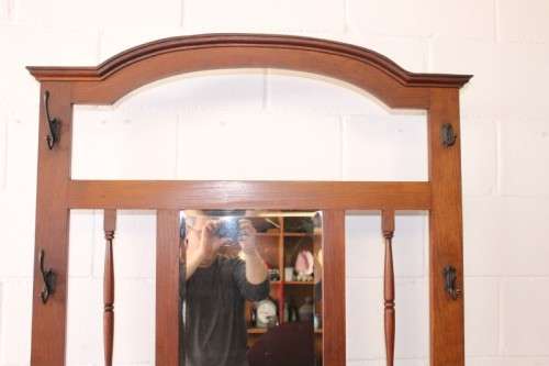 An incredible solid Oak hall stand with a bevelled mirror, "drawer" & six hooks for hats and coats!