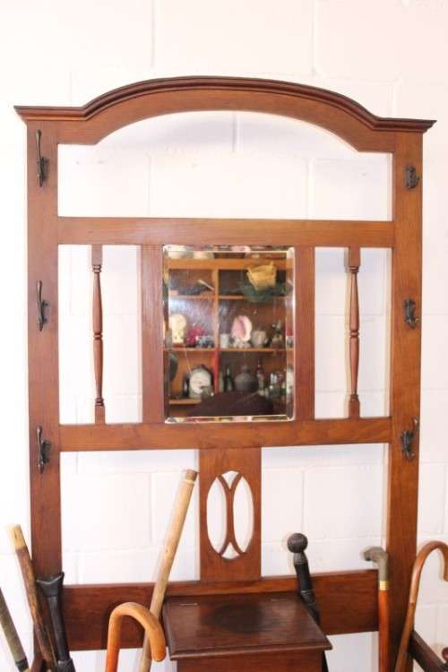 An incredible solid Oak hall stand with a bevelled mirror, "drawer" & six hooks for hats and coats!