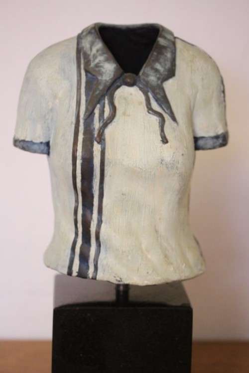 A wonderful & unusual solid cast iron sculpture of a ladies shirt set on a solid black marble base