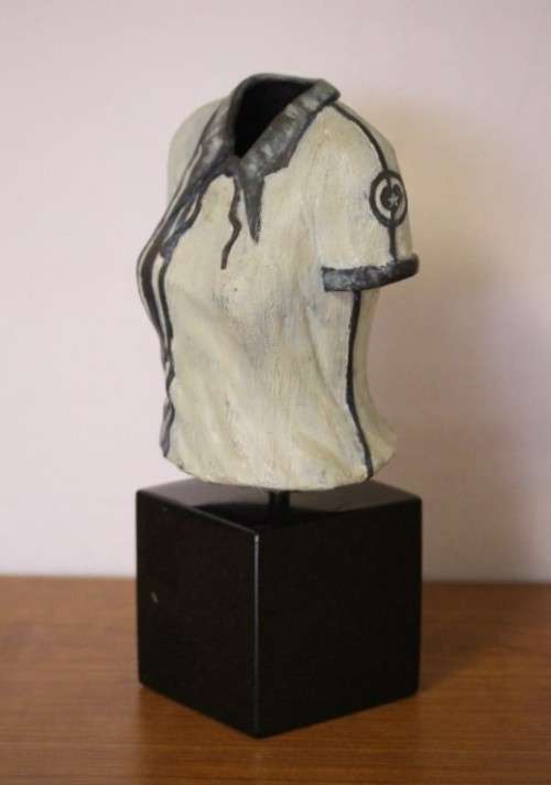 A wonderful & unusual solid cast iron sculpture of a ladies shirt set on a solid black marble base
