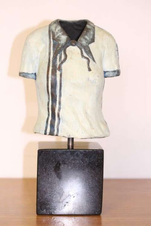 A wonderful & unusual solid cast iron sculpture of a ladies shirt set on a solid black marble base