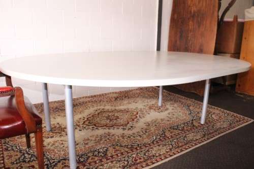 A large oval modern styled, grey painted 8 to 10-seater boardroom table on a sturdy metal frame