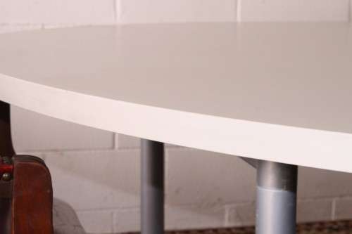 A large oval modern styled, grey painted 8 to 10-seater boardroom table on a sturdy metal frame