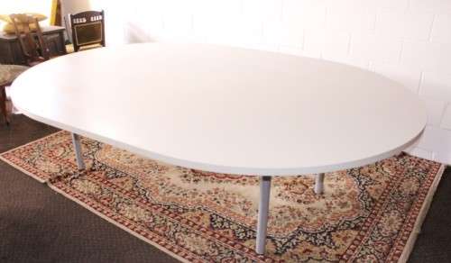 A large oval modern styled, grey painted 8 to 10-seater boardroom table on a sturdy metal frame