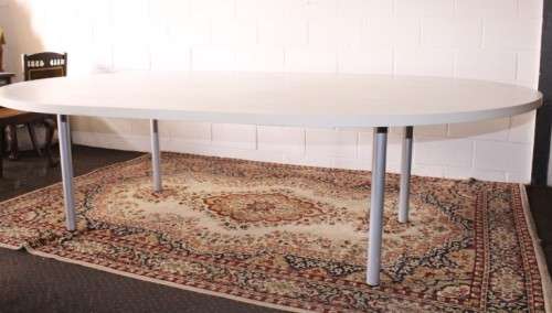 A large oval modern styled, grey painted 8 to 10-seater boardroom table on a sturdy metal frame