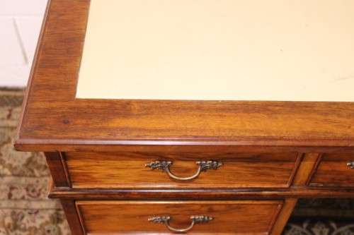 A beautiful vintage knee-hole writing desk w/ an off-white leather top & 9x drawers w/ brass handles
