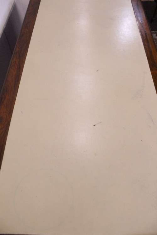 A beautiful vintage knee-hole writing desk w/ an off-white leather top & 9x drawers w/ brass handles