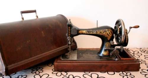 A remarkable antique (1903) Singer hand cranked sewing machine in its original casing.