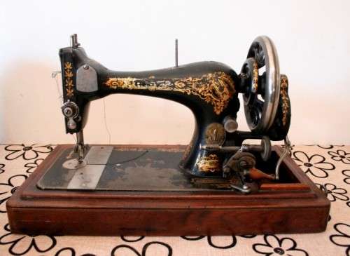 A remarkable antique (1903) Singer hand cranked sewing machine in its original casing.