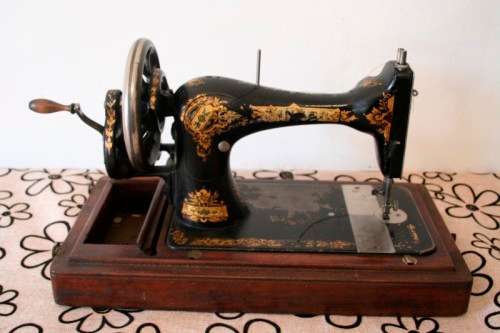 A remarkable antique (1903) Singer hand cranked sewing machine in its original casing.