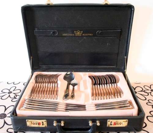 A 68-piece Edelstahl Rostfrei gold scroll trim flatware cutlery set in its original briefcase.