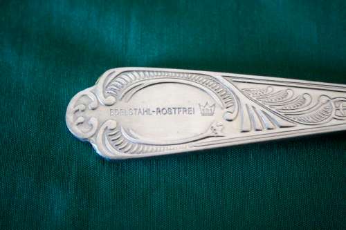 A 68-piece Edelstahl Rostfrei gold scroll trim flatware cutlery set in its original briefcase.