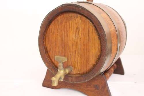 A fantastic and very well made miniature solid oak whiskey barrel on a stand w/ brass tap & stopper