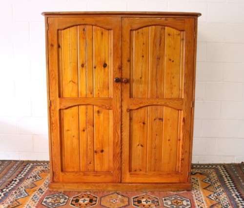 A solidly made double door SA pine storage cabinet with an array of shelves and storage space