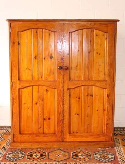 A solidly made double door SA pine storage cabinet with an array of shelves and storage space