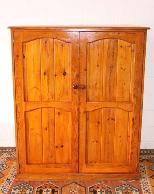 A solidly made double door SA pine storage cabinet with an array of shelves and storage space