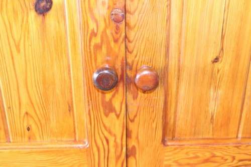 A solidly made double door SA pine storage cabinet with an array of shelves and storage space