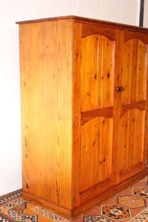A solidly made double door SA pine storage cabinet with an array of shelves and storage space