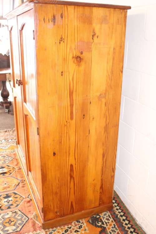 A solidly made double door SA pine storage cabinet with an array of shelves and storage space