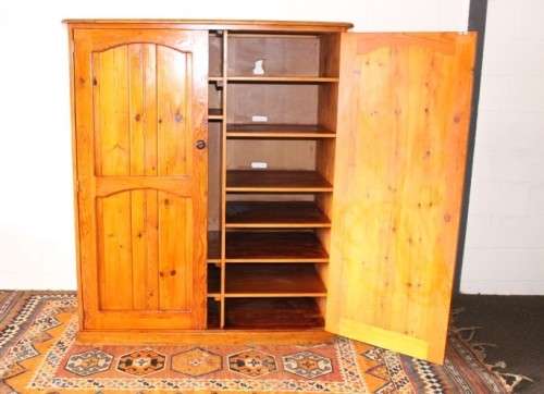 A solidly made double door SA pine storage cabinet with an array of shelves and storage space