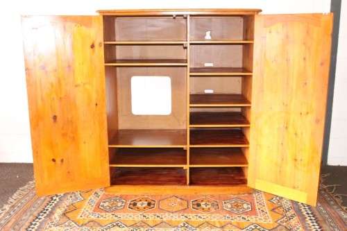 A solidly made double door SA pine storage cabinet with an array of shelves and storage space