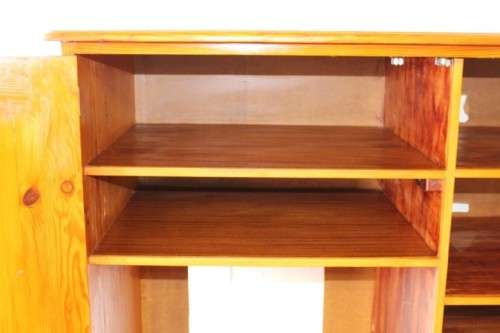 A solidly made double door SA pine storage cabinet with an array of shelves and storage space