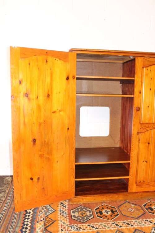 A solidly made double door SA pine storage cabinet with an array of shelves and storage space