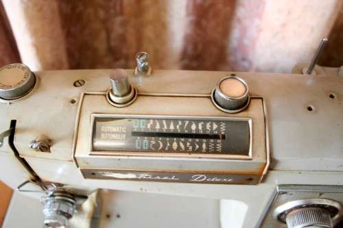 A vintage Empisal deluxe electric sewing machine in its original cabinet w/ accessories, working.