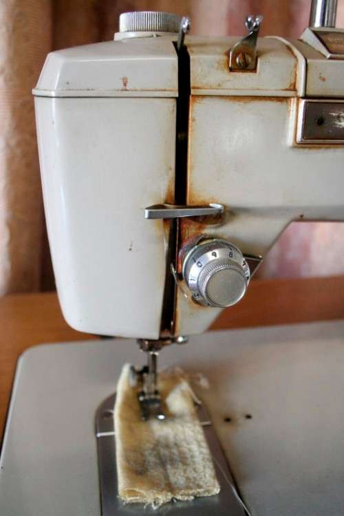 A vintage Empisal deluxe electric sewing machine in its original cabinet w/ accessories, working.