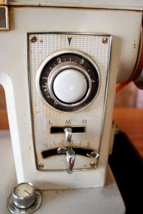A vintage Empisal deluxe electric sewing machine in its original cabinet w/ accessories, working.