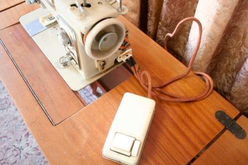 A vintage Empisal deluxe electric sewing machine in its original cabinet w/ accessories, working.