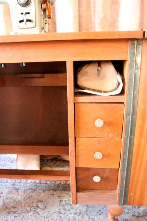 A vintage Empisal deluxe electric sewing machine in its original cabinet w/ accessories, working.