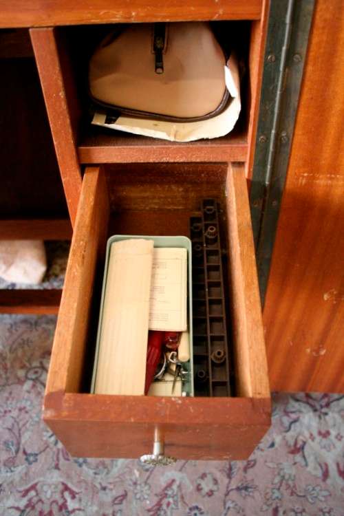 A vintage Empisal deluxe electric sewing machine in its original cabinet w/ accessories, working.