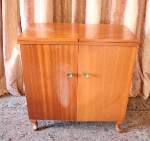 A vintage Empisal deluxe electric sewing machine in its original cabinet w/ accessories, working.