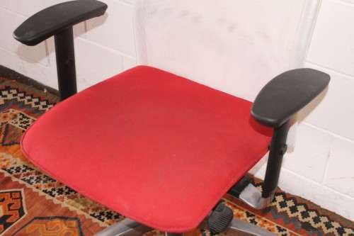 A modern styled red and white office chair with tilt, height and tension adjusters