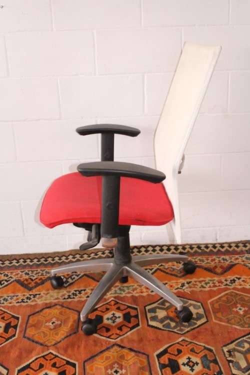 A modern styled red and white office chair with tilt, height and tension adjusters