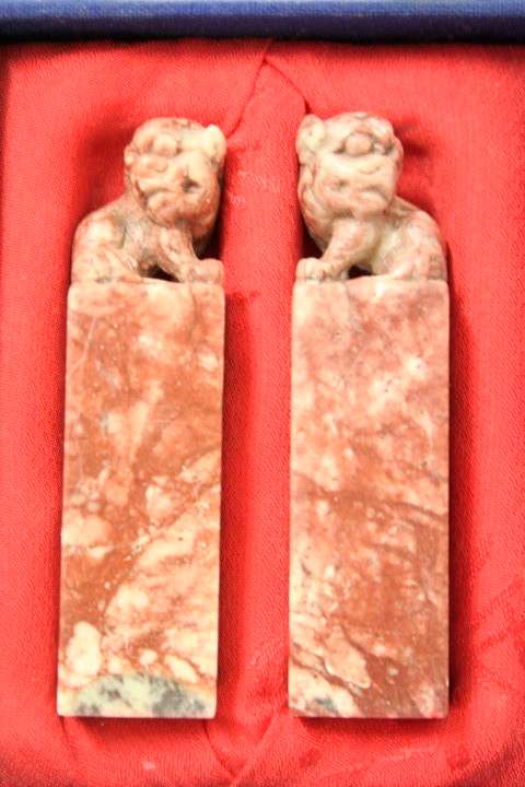 An incredible boxed pair of hand carved red-marble Feng Shui Foo Dog/ Temple Lion ornaments
