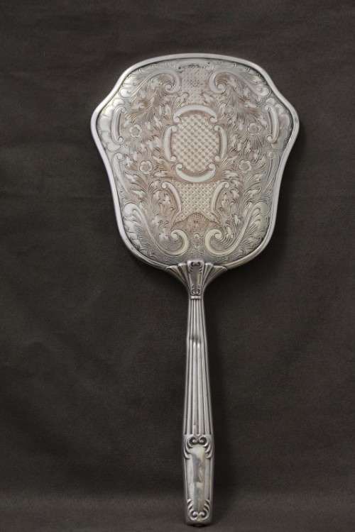 A beautiful antique vanity brush & mirror set w gorgeous pressed detailing.